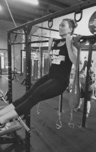 A woman completes a pull up at Elite Edge.